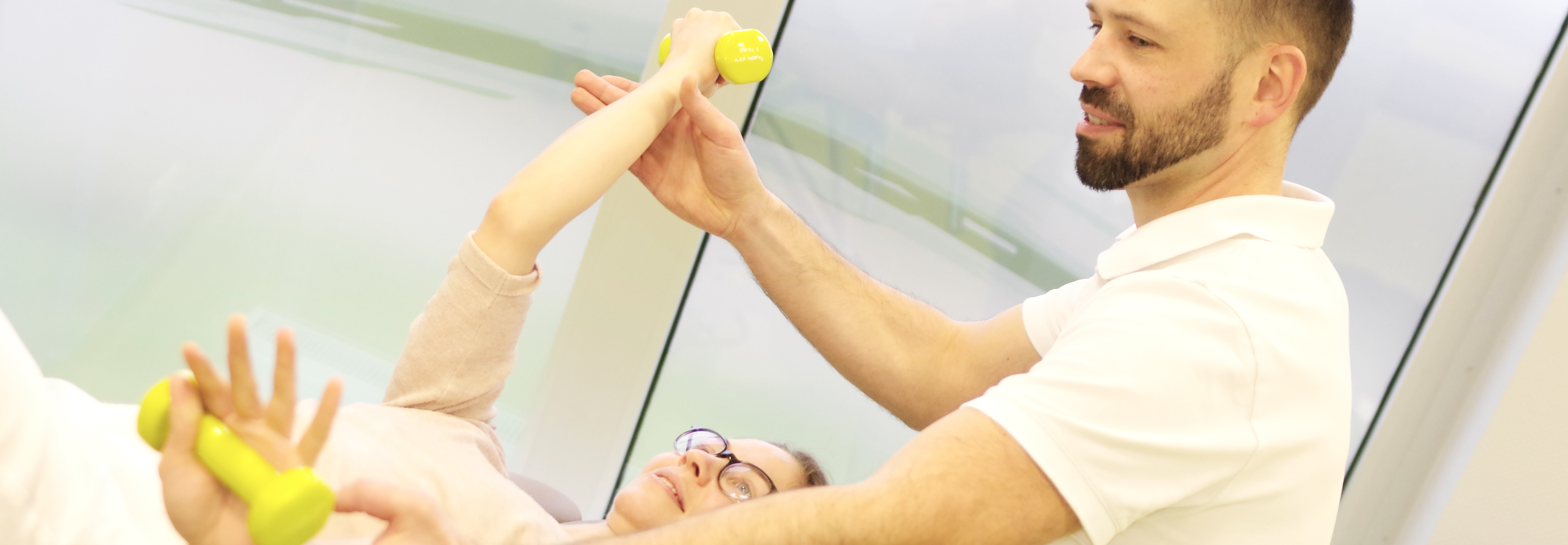Physiotherapeut begleitet einen Patienten bei einer aktiven Rückenübung in der Praxis Beger in Leipzig